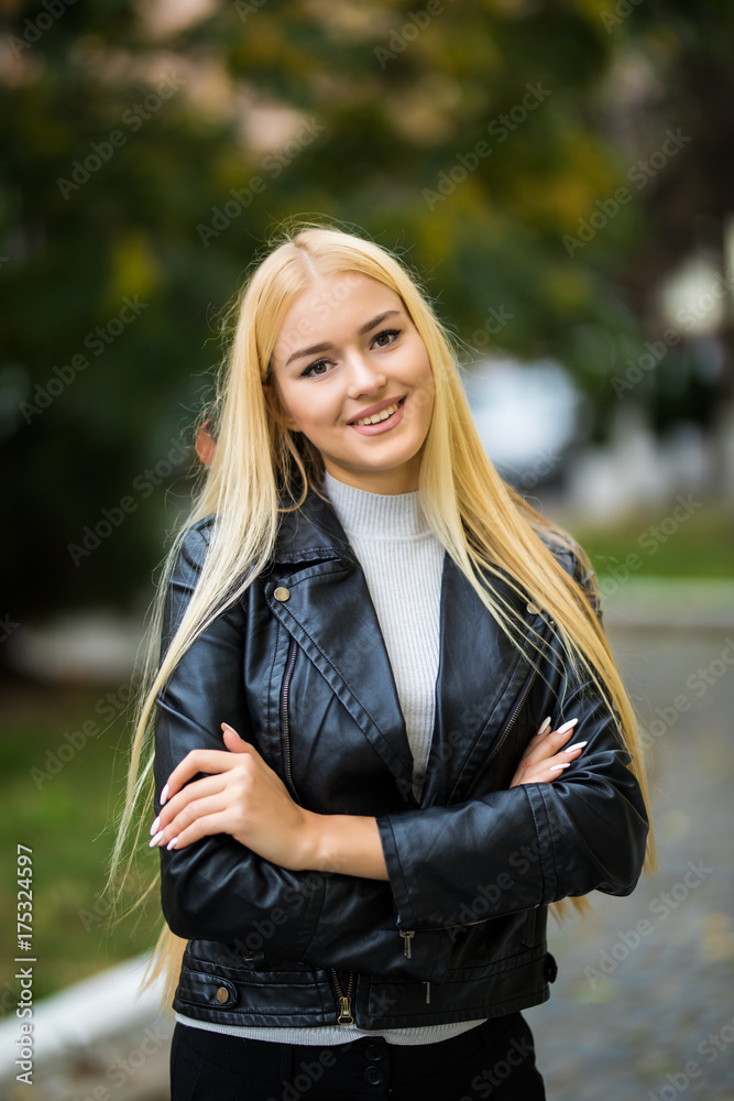 young smiling woman i with her hands crossed and looking in camera in the street