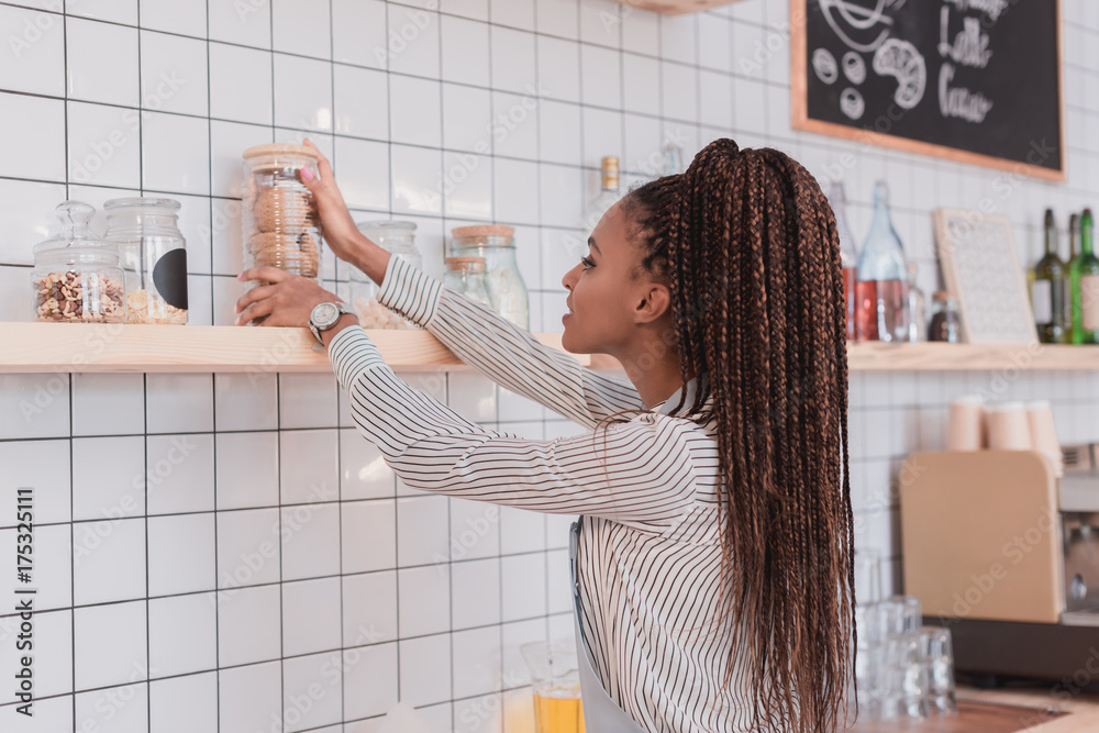barista taking glass jar wth cookies barista taking glass jar wth cookies
