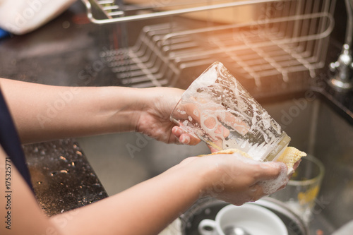 A woman washing glass by dish soap