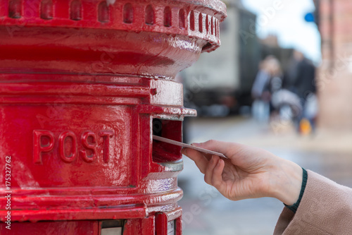 Throwing a letter in a red British post box photo