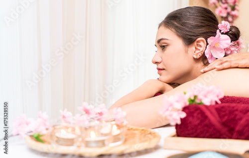 Women lying on a spa bed with flwoer and candles photo