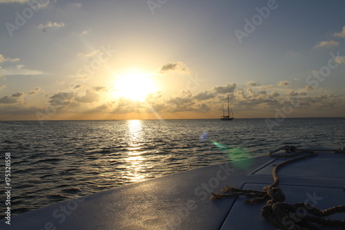 Barche al tramonto sull'oceano in Belize, con corda di ormeggio sulla prua