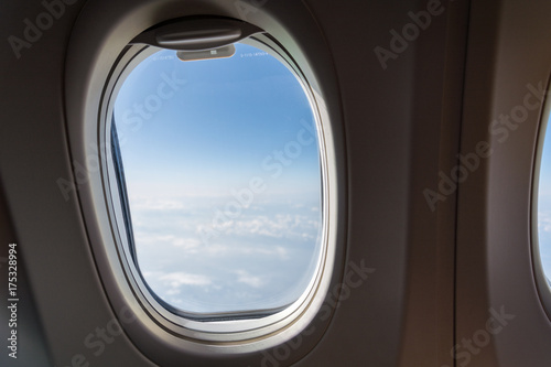 Single window of an airplane with clouds © Asvolas