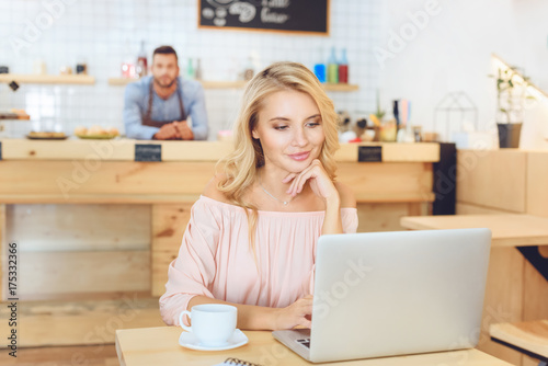 woman using laptop in cafe