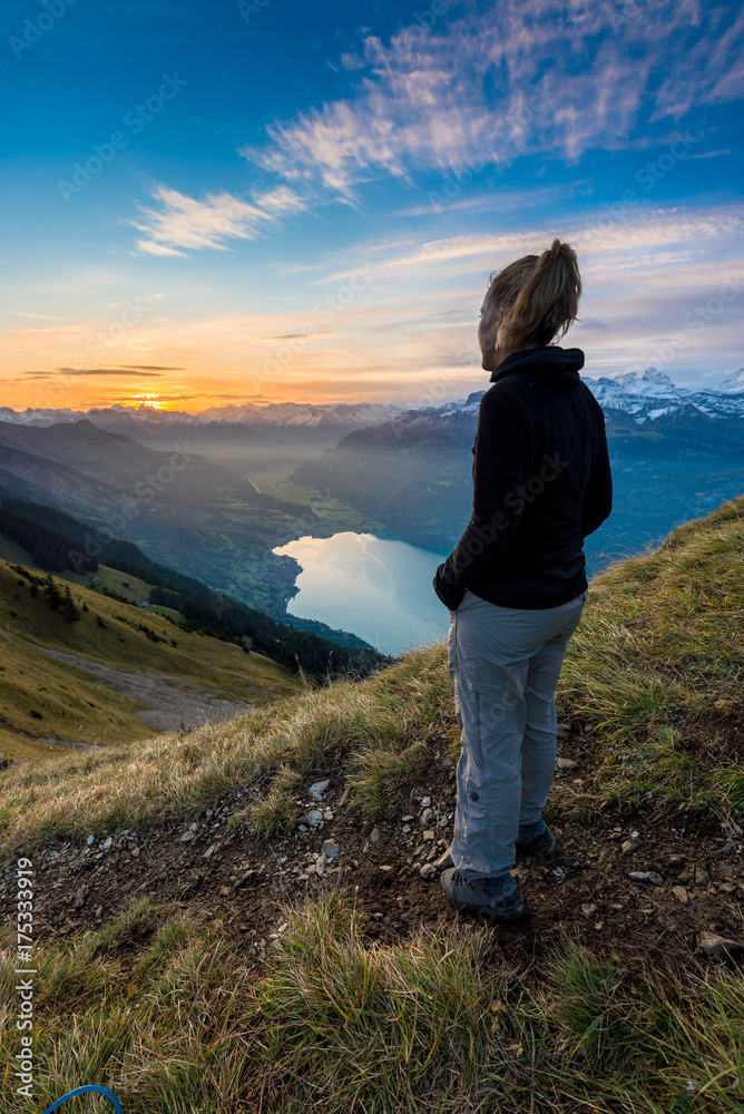 Wanderin blickt in Sonnenaufgang über Brienz und Brienzersee, Berner Oberland, Schweiz