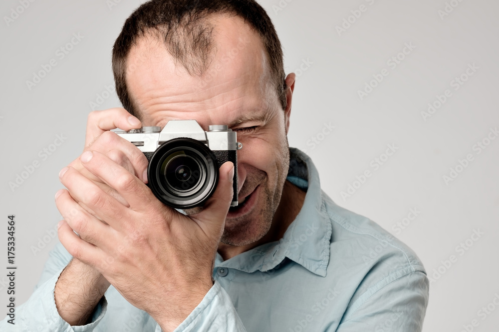 Mature caucasian man in blue t-shirt studing to use digital camera Mature caucasian man in blue t-shirt studing to use digital camera