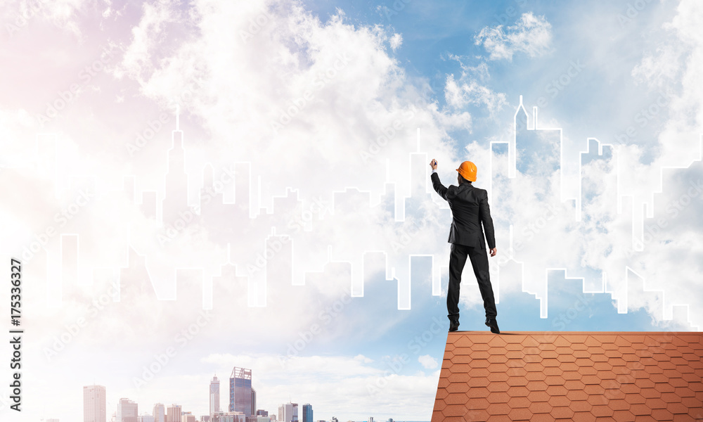 Man architect draw silhouette of modern city on blue sky. Mixed media Man architect draw silhouette of modern city on blue sky. Mixed media