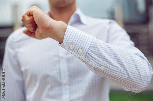 Close up of a businessman in a white shirt and shows the sleeve of the shirt and the hand.