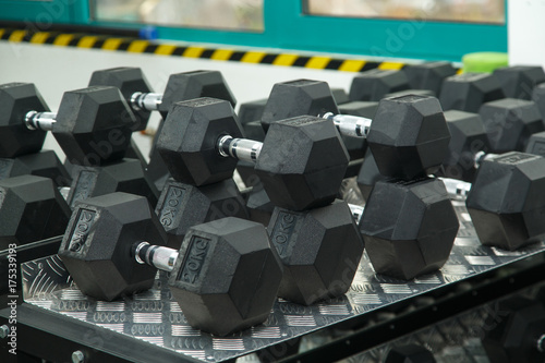 Fitness room. Energy for the day. Gym. Gymnasium with sports equipment. Dumbbells  barbells  dumbbells - equipment to work on muscle mass. Rows of dumbbells in the gym. light