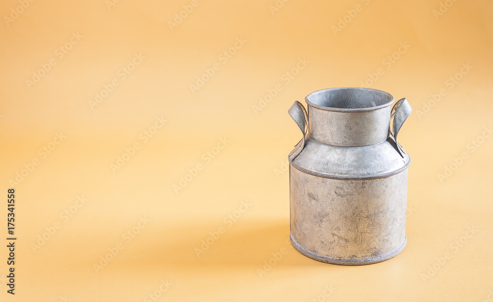 Water cans made of tin on yellow background Water cans made of tin on yellow background