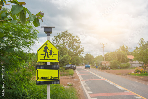 Yellow sign school zone symbol in the countryside .