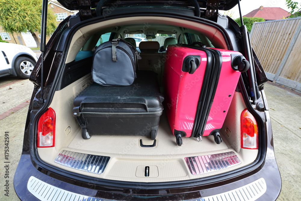 Suit cases packed for a holiday into an estate car. Suit cases packed for a holiday into an estate car.