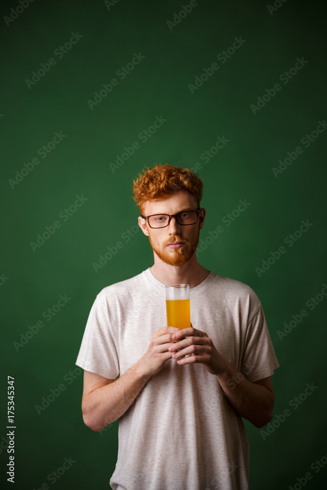 Portrait of a young redhead man holding glass of beer Portrait of a young redhead man holding glass of beer