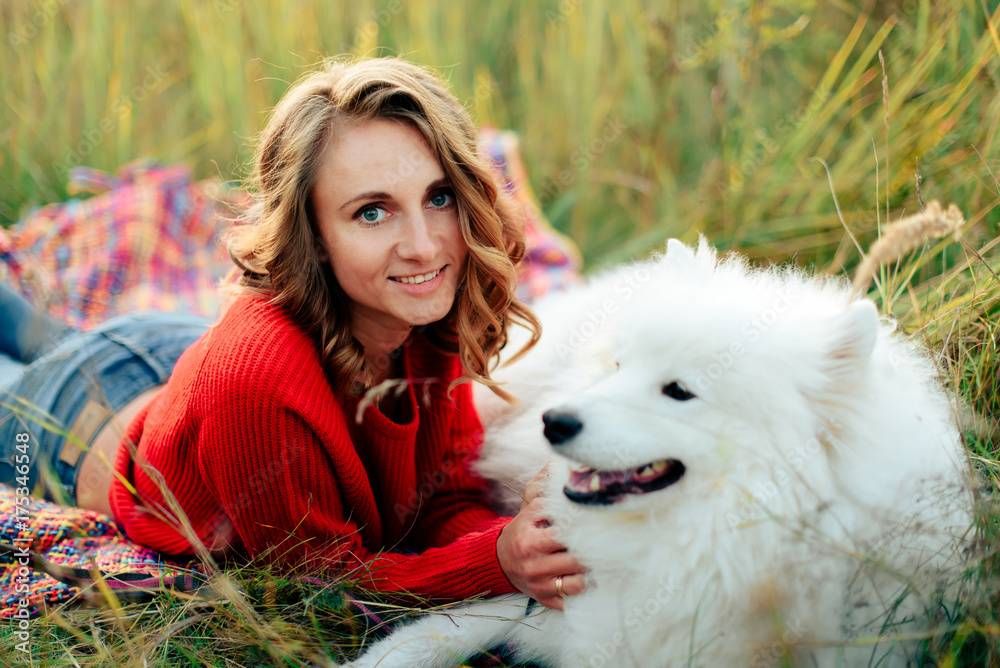 young girl in a nature park hugging a white dog Samoyed Laika at sunset young girl in a nature park hugging a white dog Samoyed Laika at sunset