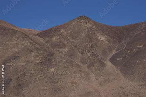 Large group of ancient petroglyphs on the hillsides at Cerro Pintados in the Atacama Desert in the Tarapaca Region of northern Chile.  photo