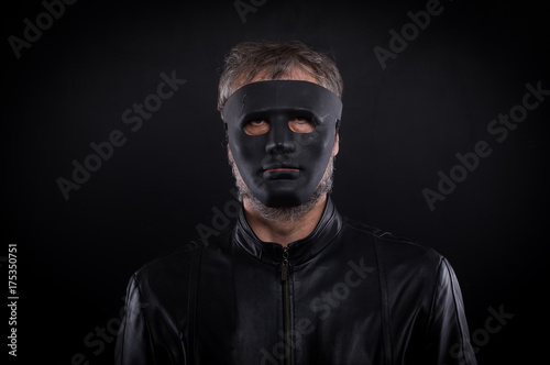 Mystery man holding black  mask. Anonymous social masking concept.