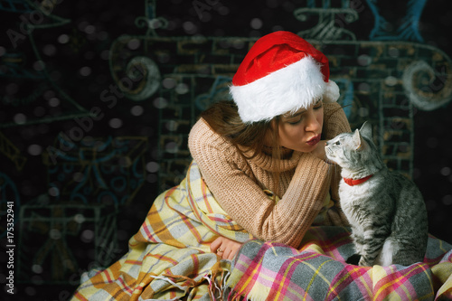 girl playing with a cat on a Christmas background
