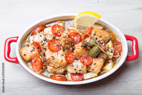 Salmon baked with sesame, tomatoes and zucchini. Close-up. Selective focus.