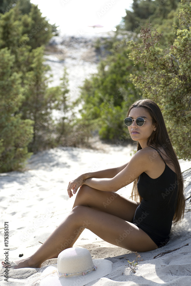 giovane donna seduta sulla spiaggia 
