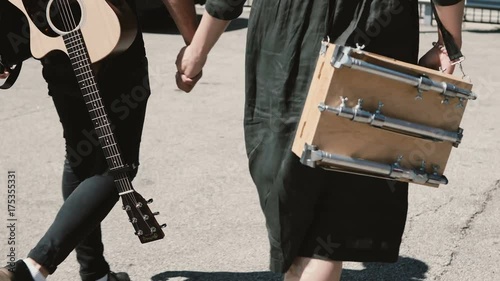 Young beautiful couple walking in downtown together, Chicago, America. Man holding guitar, woman sketchbox. photo