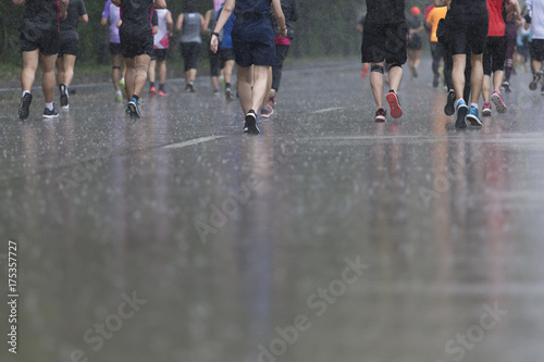 back man Marathon runners focus clear running shoes on the street with rain.