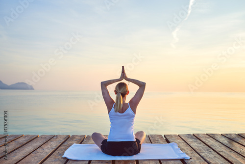 Schlanke Frau macht Yoga Übung am Meer