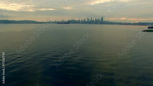 Seattle, WA downtown waterfront view at sunrise, early mourning, warm colors, calm water and some light fog, establishing shot
