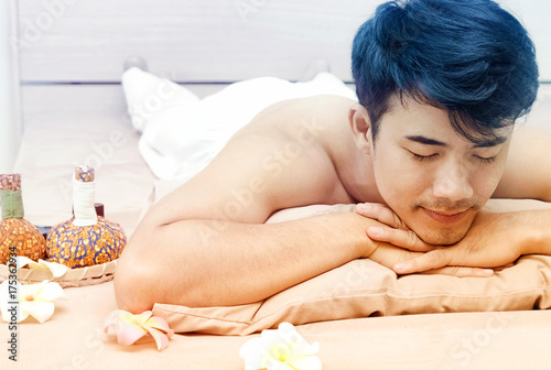 Young Asian man relaxing on massage desk
