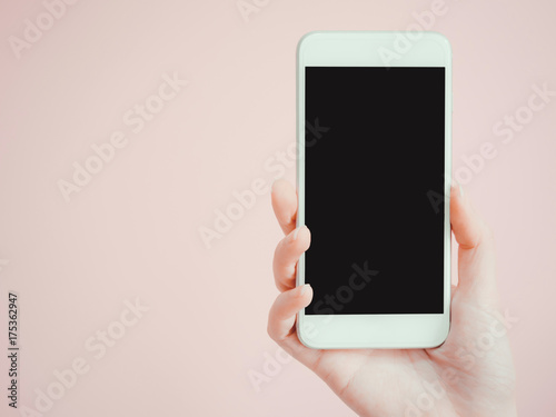 holding and show smart phone by asian woman beauty right hand with pink pastel background