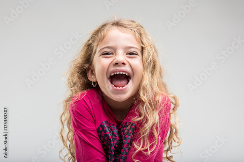Laughing schoolgirl with curly hair