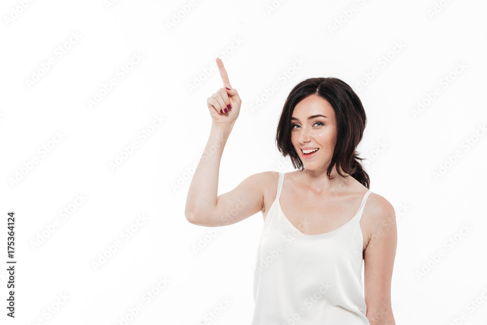 Portrait of a smiling lovely woman pointing finger up Portrait of a smiling lovely woman pointing finger up