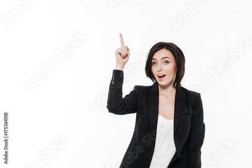 Portrait of an excited pretty businesswoman in a suit pointing © Drobot Dean