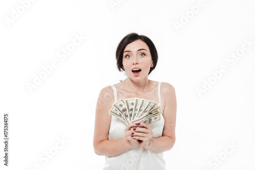 Portrait of a shocked pretty woman holding bunch of money