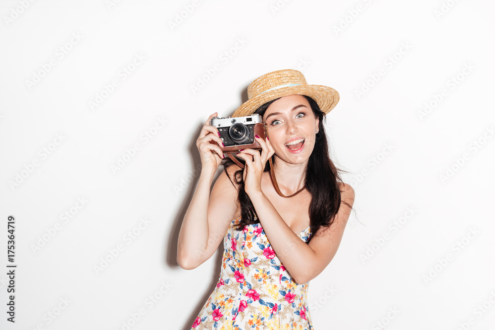 Happy brunette woman making photo on retro camera