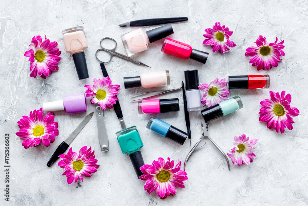 Preparing for manicure. Tools and nail polishes on grey background top view Preparing for manicure. Tools and nail polishes on grey background top view