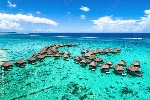 Beach travel vacation Tahiti hotel overwater bungalows luxury resort in coral reef lagoon ocean. Moorea, French Polynesia, Tahiti, South Pacific Ocean.