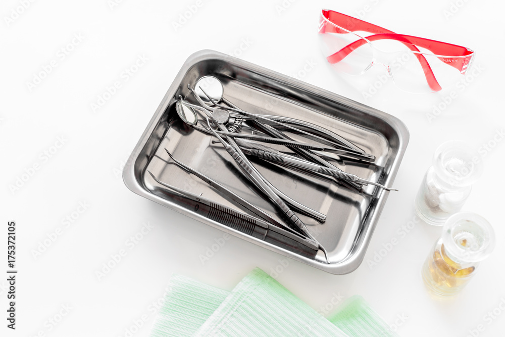 Dentists accessories. Tools in cuvette, safety glasses and pills on white background copyspace Dentists accessories. Tools in cuvette, safety glasses and pills on white background copyspace