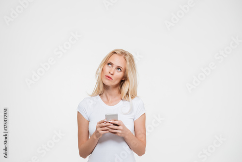 Portrait of a pensive woman holding mobile phone