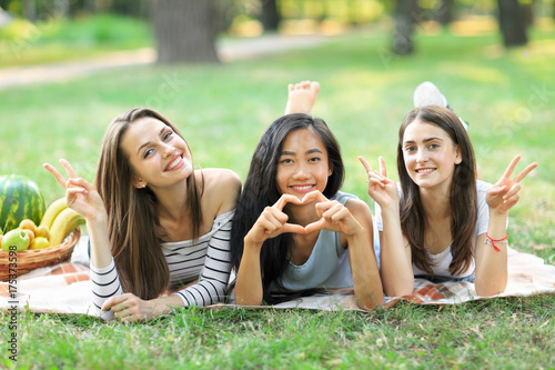 Portrait of three young women showing sign peace and heart