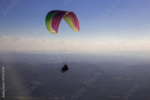 Paraglider flies in the blue sky.