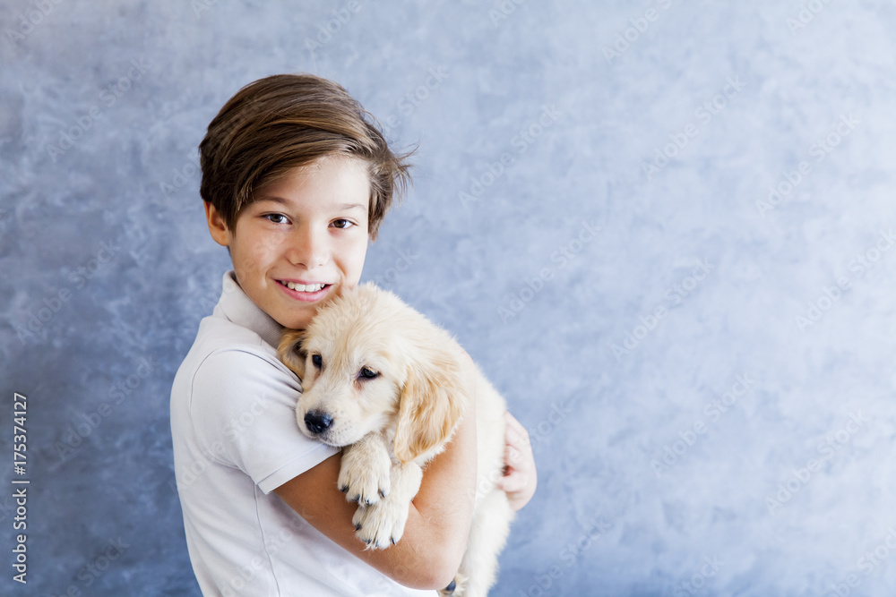 Teenage boy holding the golden retriever baby dog Teenage boy holding the golden retriever baby dog