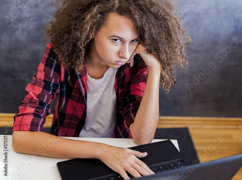 фотографія Unhappy teenage girl using laptop at h ome