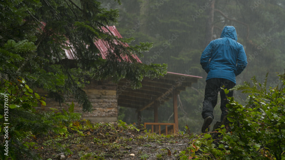 man walking on the wood house walking in the rain