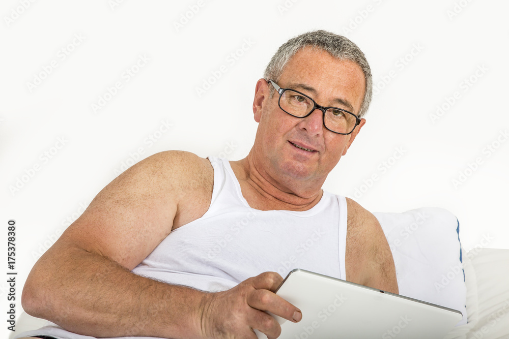 Man with tablet pc is lying in bed Man with tablet pc is lying in bed