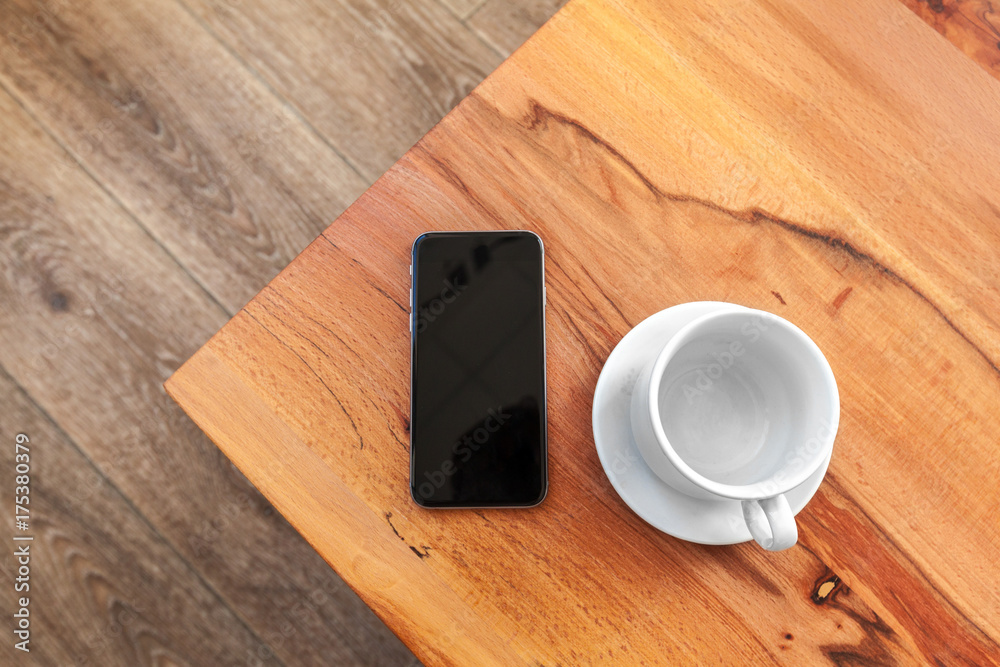 Mobile phone with blank screen mockup on wood table background Mobile phone with blank screen mockup on wood table background