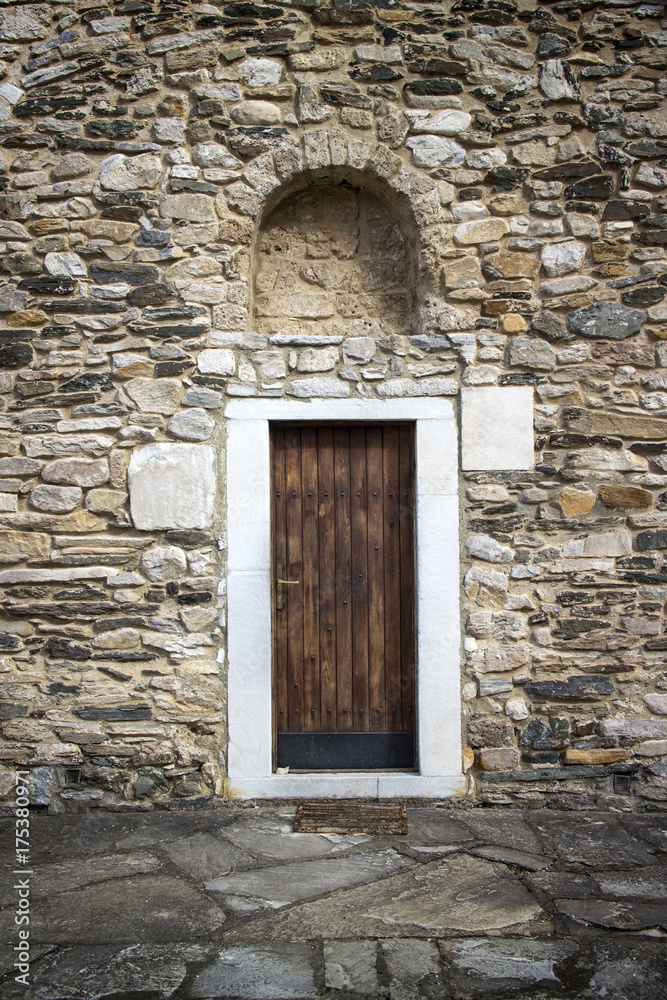 Ancient wooden door in stone castle wall.