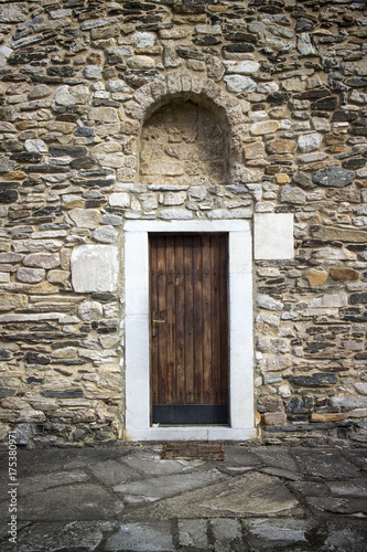 Ancient wooden door in stone castle wall.