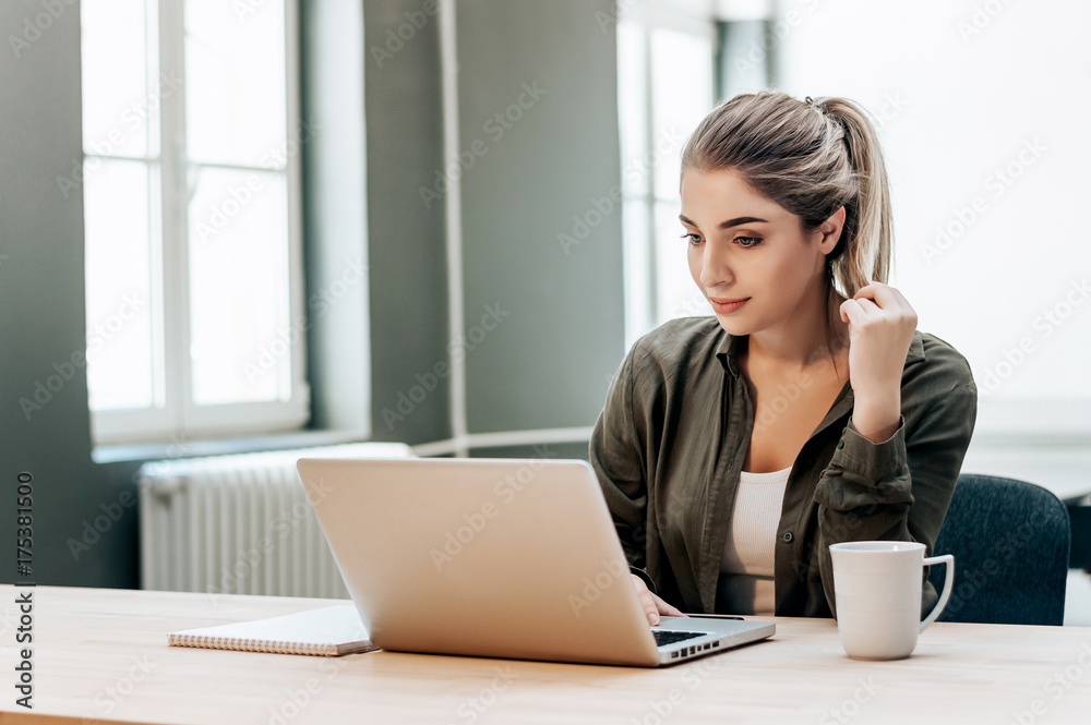 Young pretty smiling student chatting with friends on laptop. Young pretty smiling student chatting with friends on laptop.