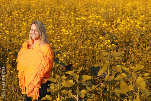 Attractive happy mature woman with orange shawl in nature