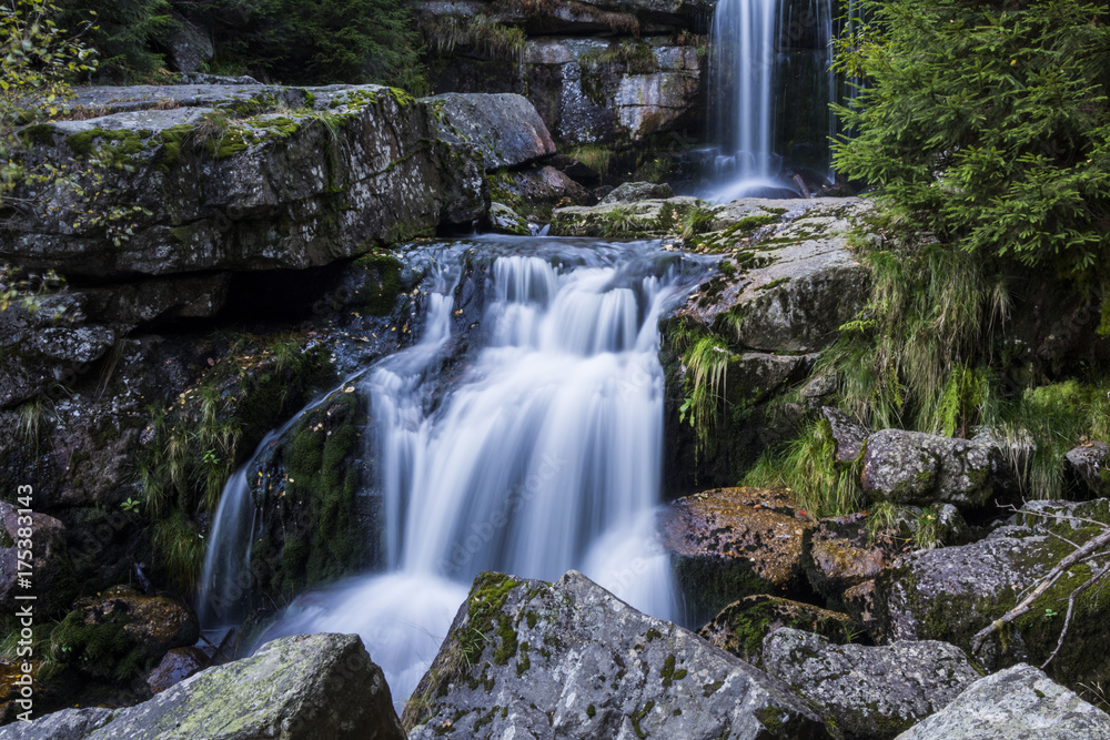 Waterfall falling on stones through autumn forest. Fall nature specification. Waterfall falling on stones through autumn forest. Fall nature specification.